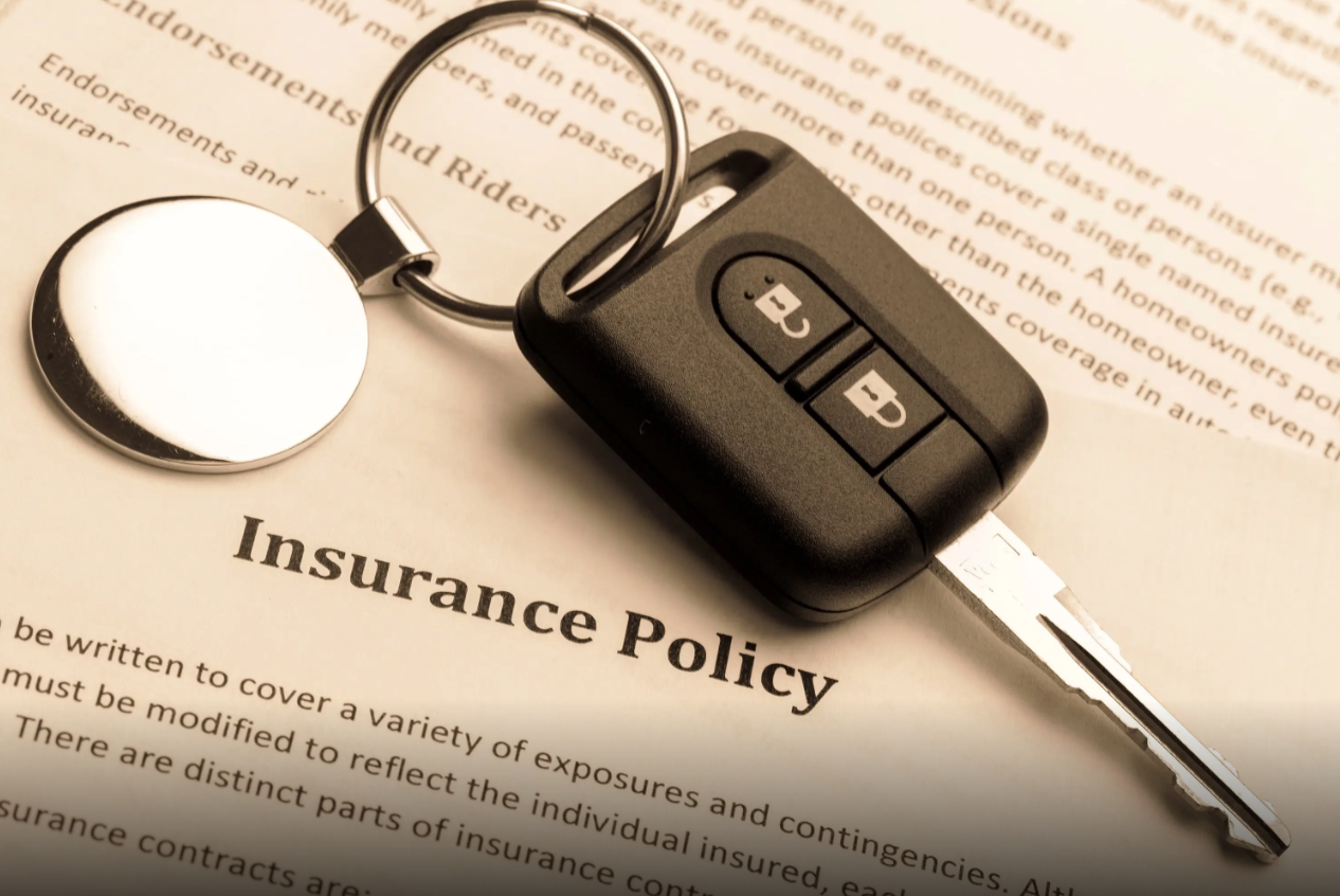 An insurance policy and keys to an insured car